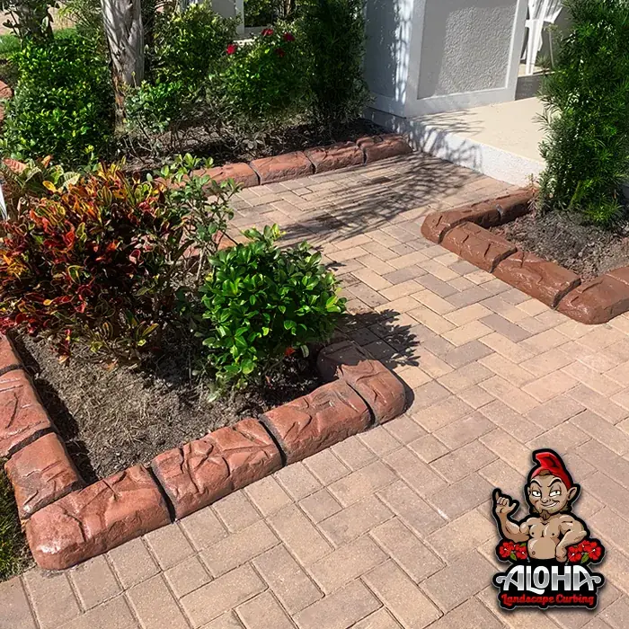 Concrete curbing holding decorative rock inside a bed