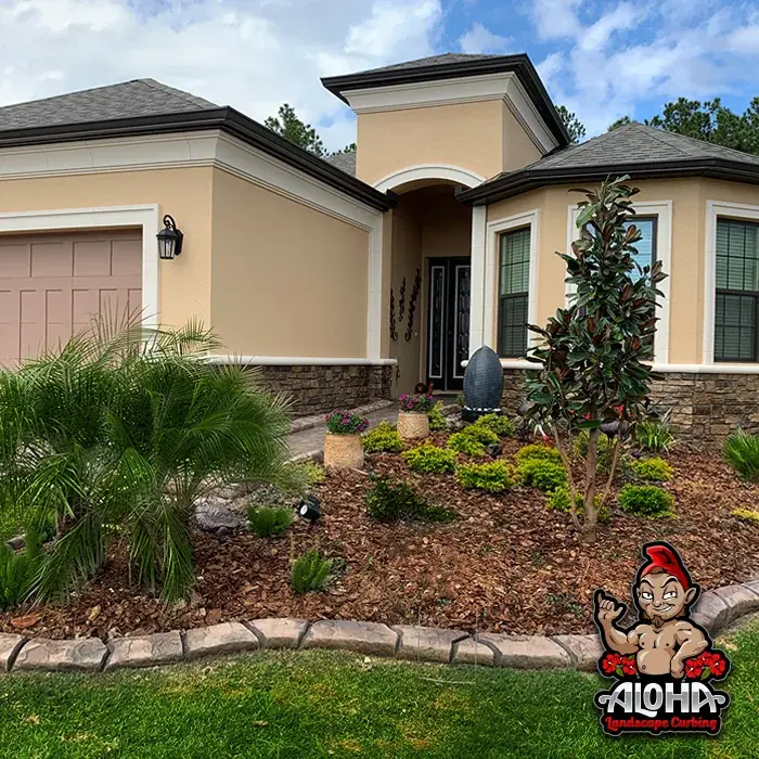 Concrete curbing separating a lawn from a planted bed