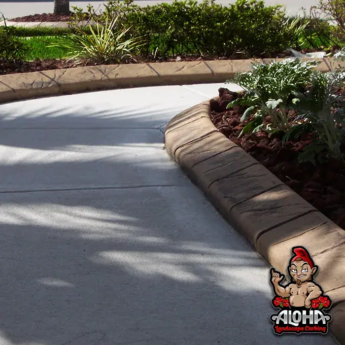 Concrete curbing holding a mulched bed at a set distance from a wall